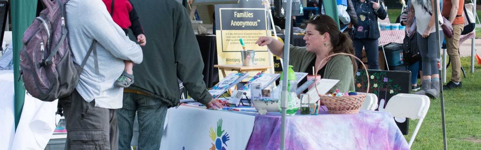 Women at vendor table talking to 2 individuals