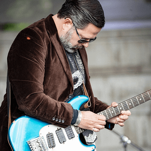 Man playing a blue electric guitar